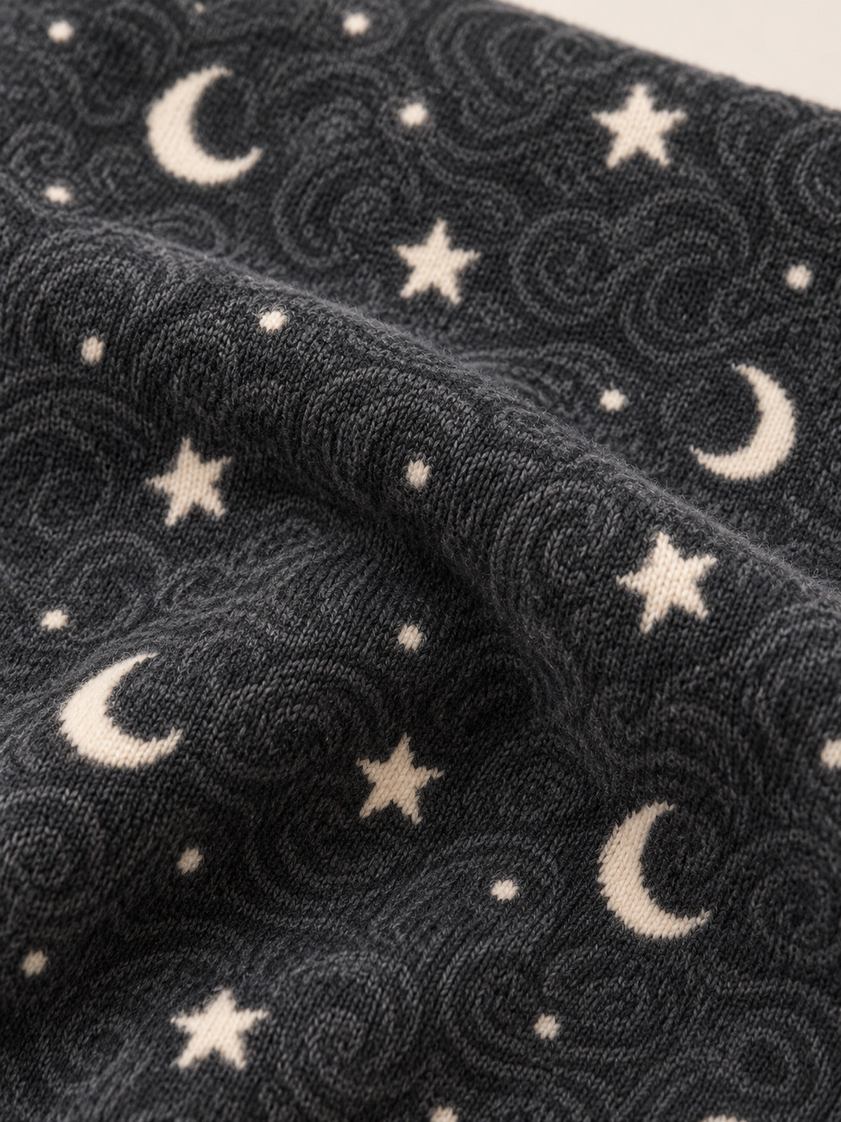 Close-up of the charcoal star-and-moon patterned fabric with cream motifs