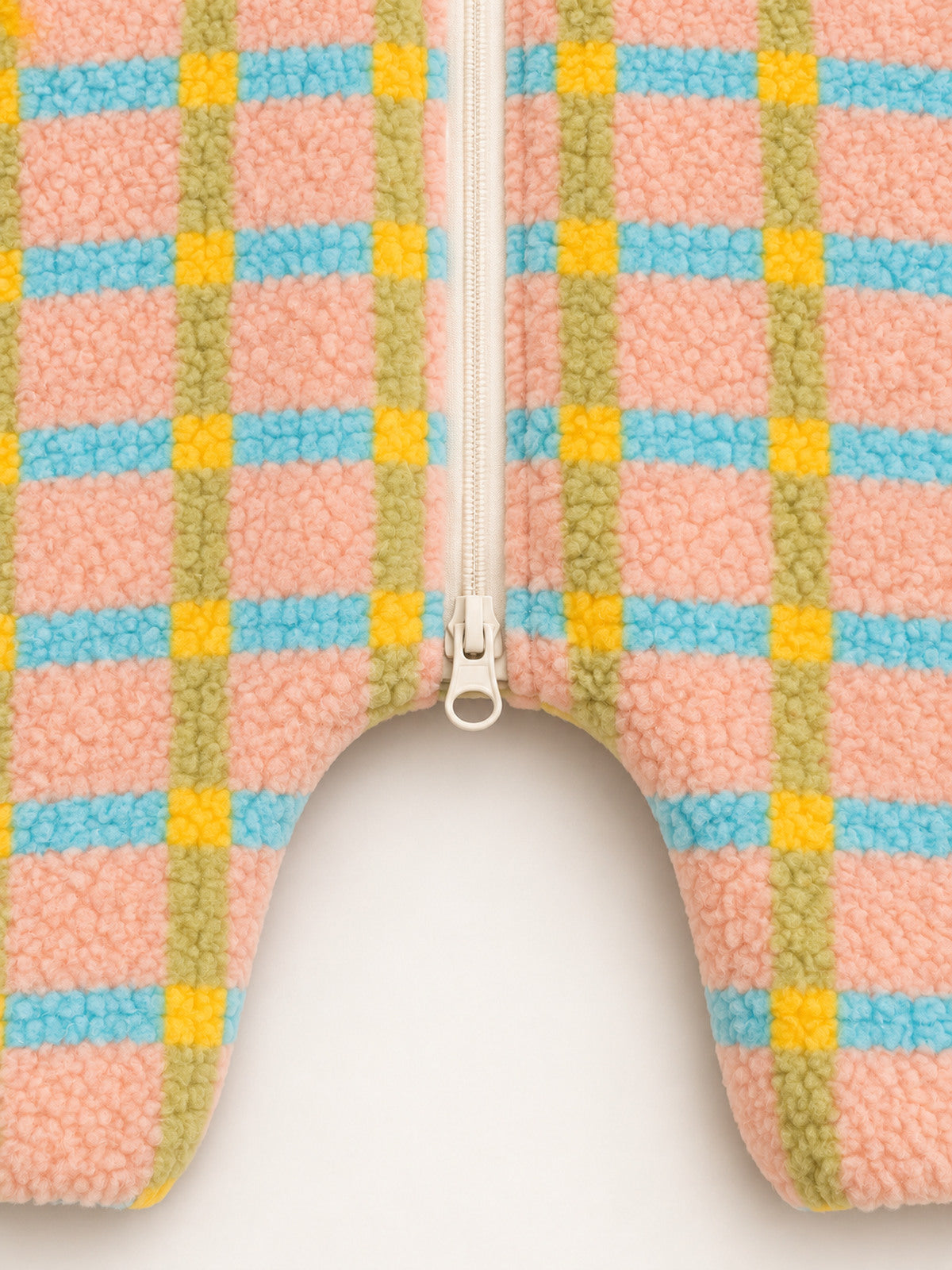 Close-up of the lower ring-pull zipper and dropped crotch on the pastel plaid onesie