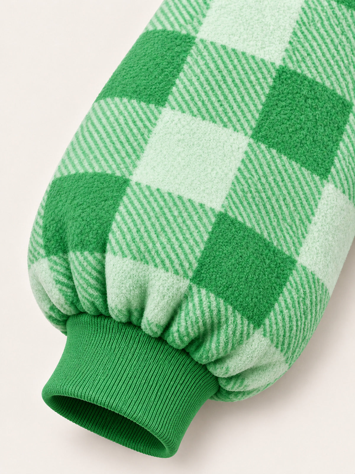 Close-up of the green gingham sleeve and matching ribbed wrist cuff