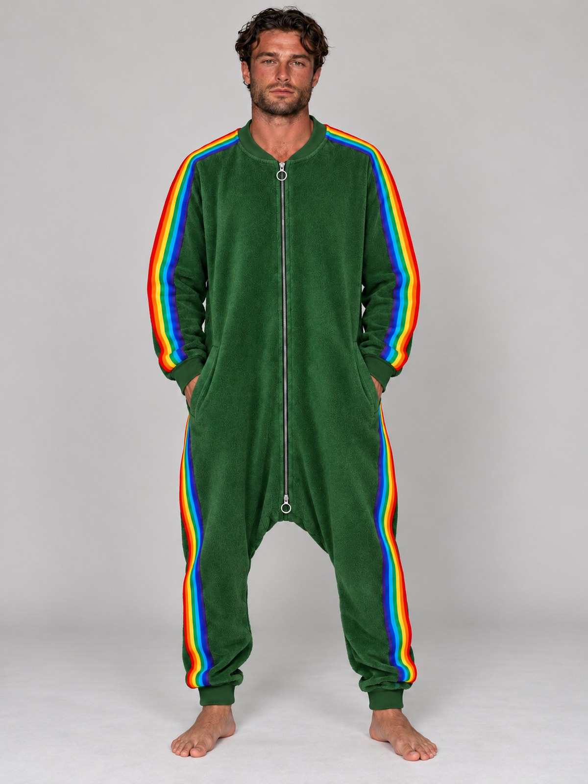 Adult man wearing the forest green rainbow stripe terry onesie with a plain chest