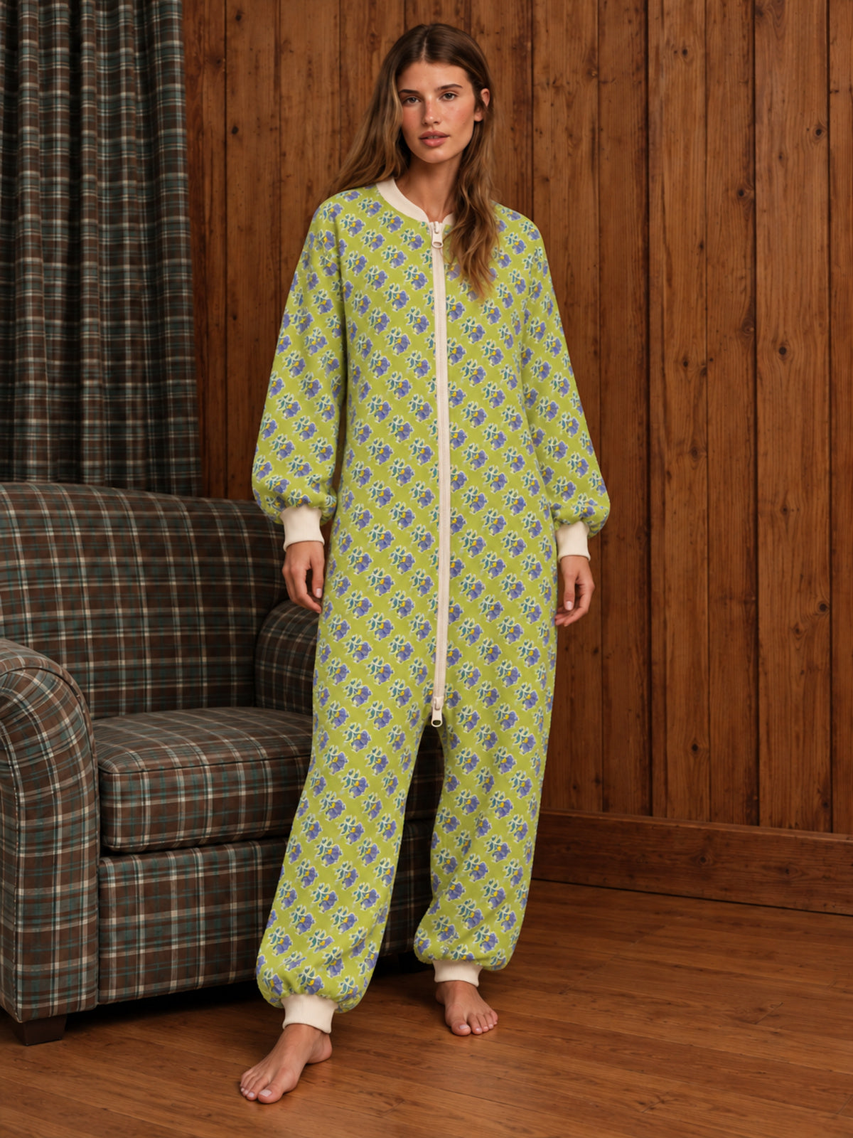 Adult woman wearing a lime-green floral onesie in a wood-panelled room