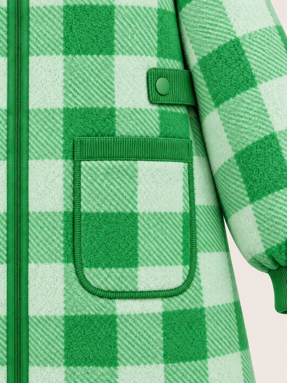Close-up of the green gingham patch pocket with green edging and a waist snap tab