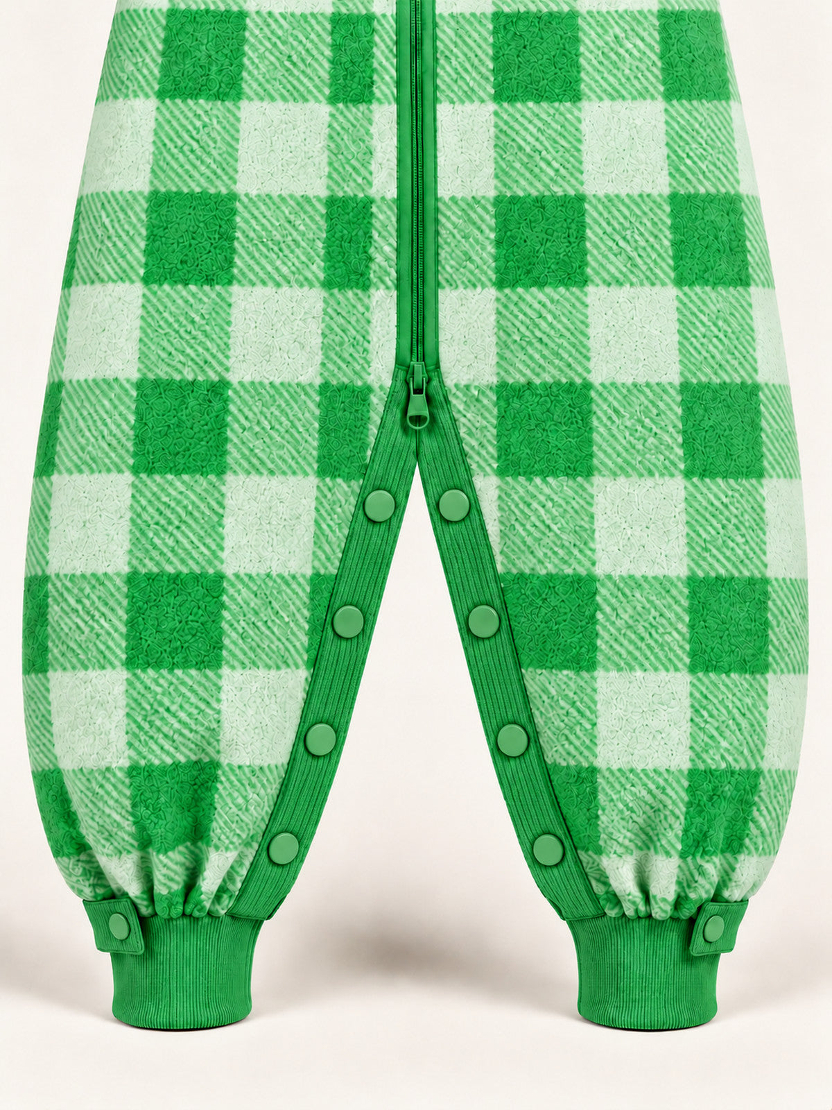 Close-up of the green gingham onesie's lower zip pull, inner-leg snaps and ribbed ankle cuffs