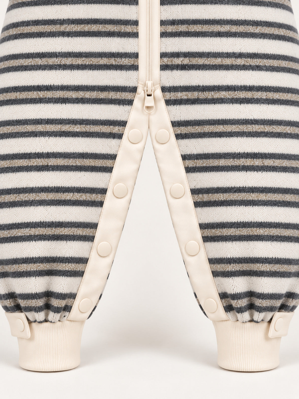 Close-up of the striped adult onesie's inner-leg snaps, lower zip pull and ribbed ankle cuffs