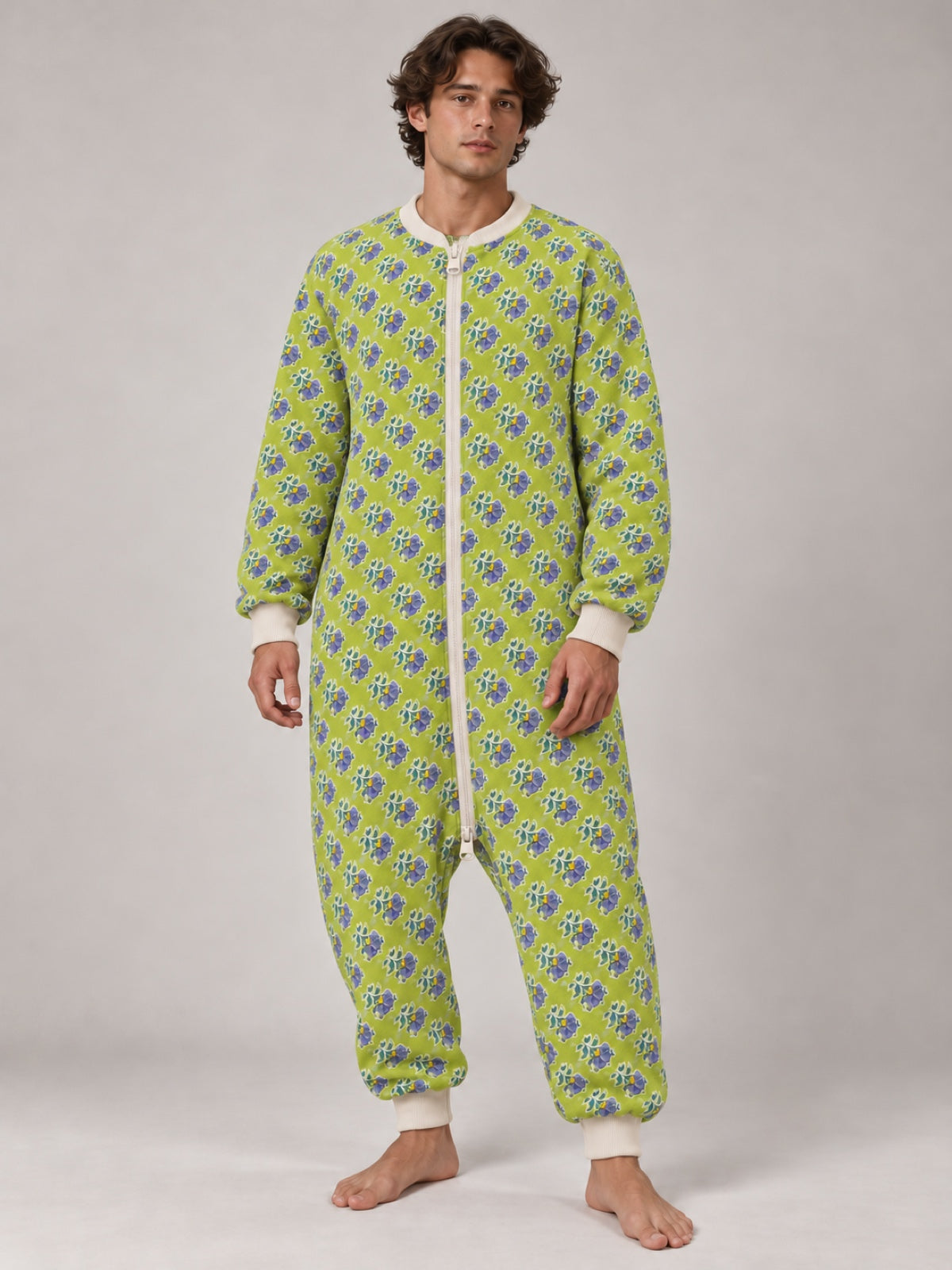 Adult man wearing a lime-green floral zip-front onesie in a studio