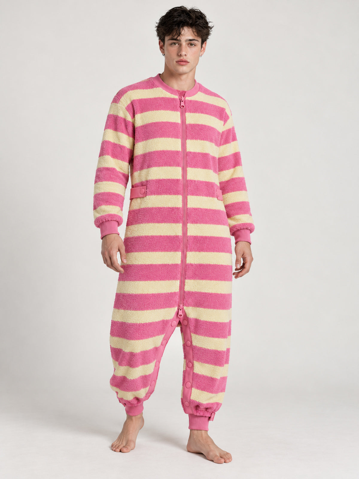 Adult model wearing a pink-and-yellow striped terry onesie, front view